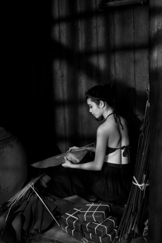 an older woman sitting by her basket, in a black and white po