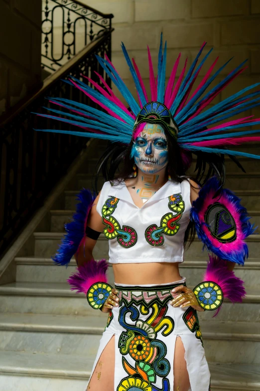 a woman wearing makeup and feathers is standing on some steps