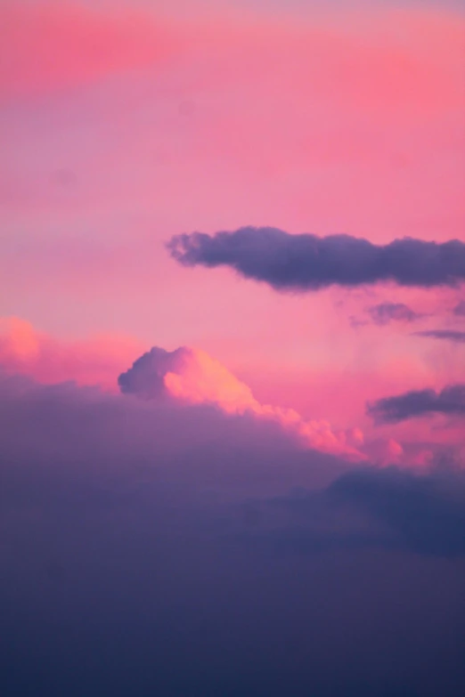 a plane in the air during a sunset with its lights on