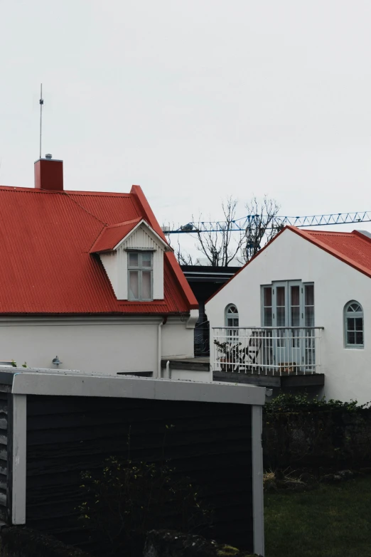 a house sitting next to a fence with a red roof