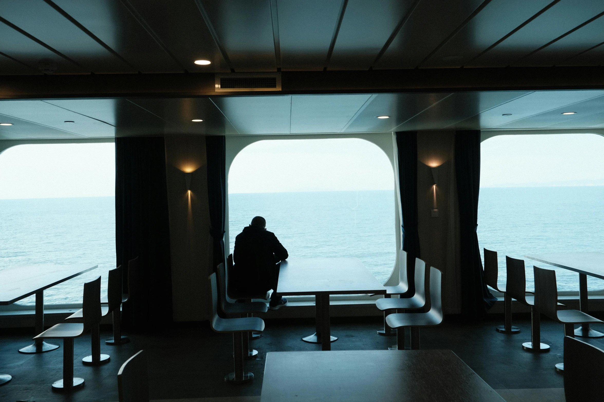 person standing on deck looking out to water