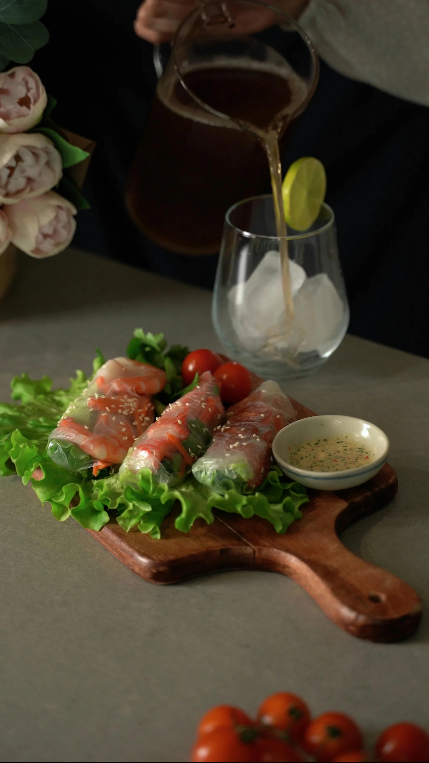 someone pouring dressing over a salad on a wooden serving board