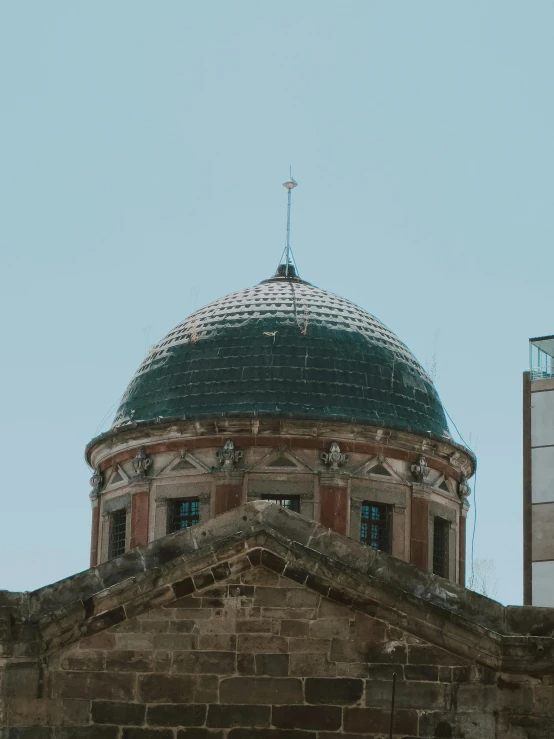 a large building with a dome roof with a blue sky in the background