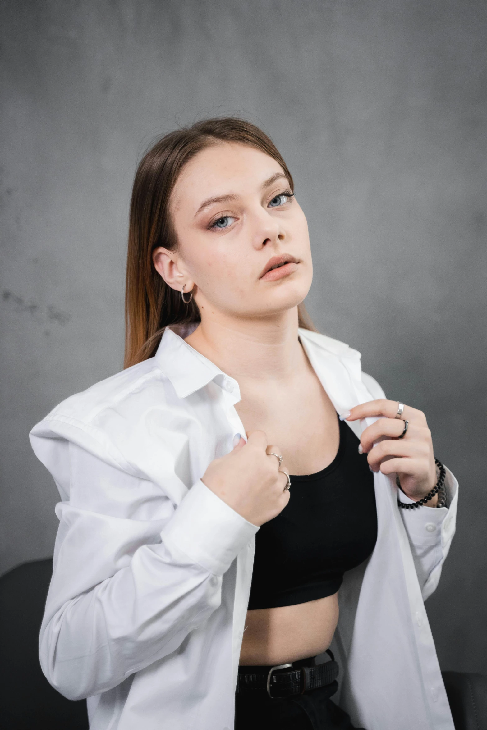 a woman sitting and wearing a white shirt