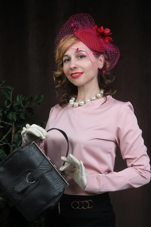 a woman in pink is holding a black purse