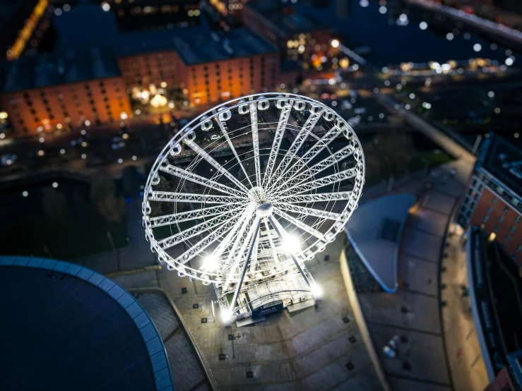 an aerial view of a ferris wheel lit up at night
