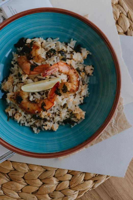 the plate has shrimp, rice, and carrots in it