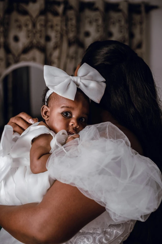 a little girl is wearing a white dress with a big bow