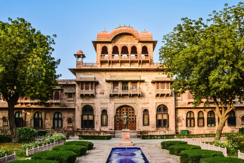 an old style building that has many trees in front of it