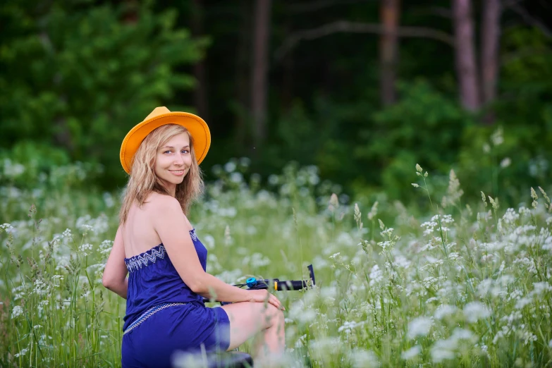 the  is sitting in the grass with her bicycle