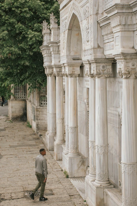 a person with a skateboard near many tall white columns