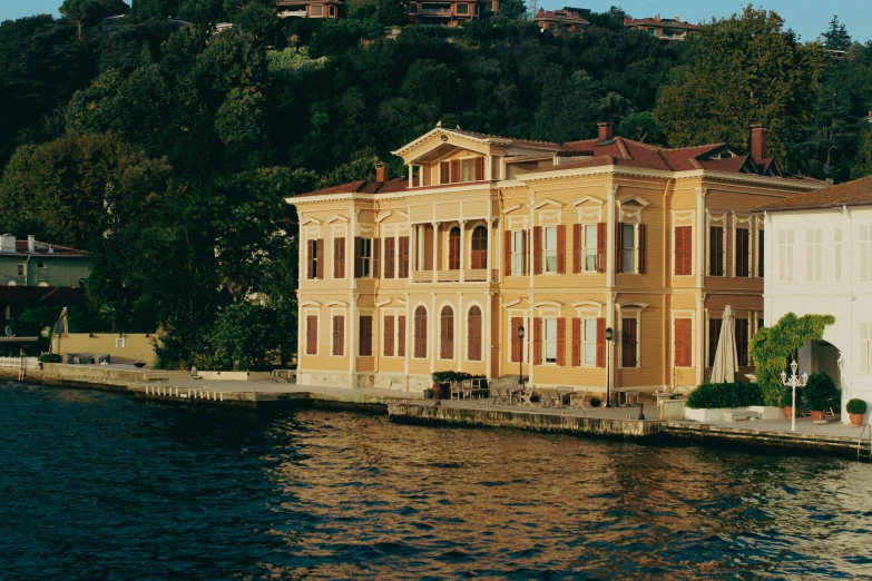 a mansion sits at the edge of a body of water