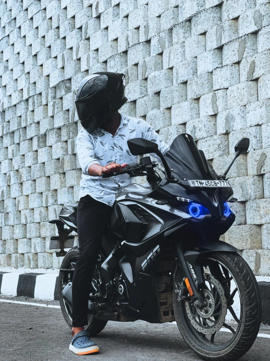 a person riding on a motorcycle in front of a wall