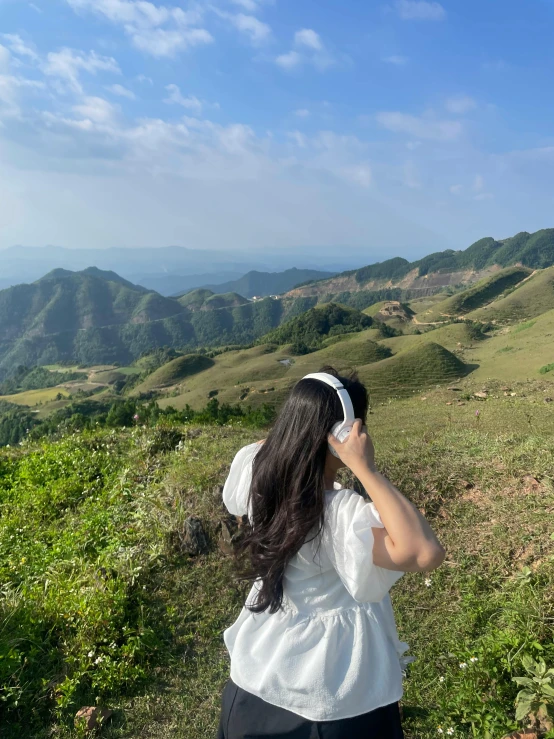 a girl is standing in the field on her phone