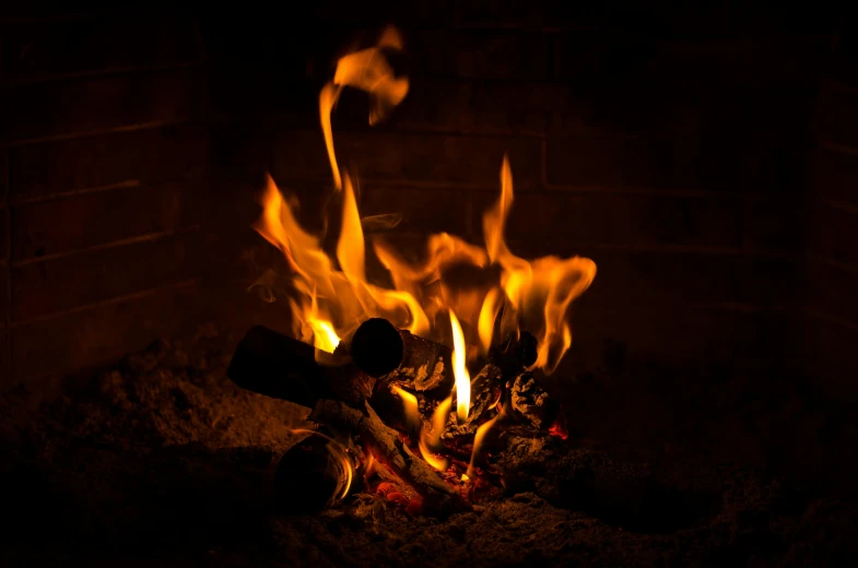 the fire is blazing on a fireplace in the dark