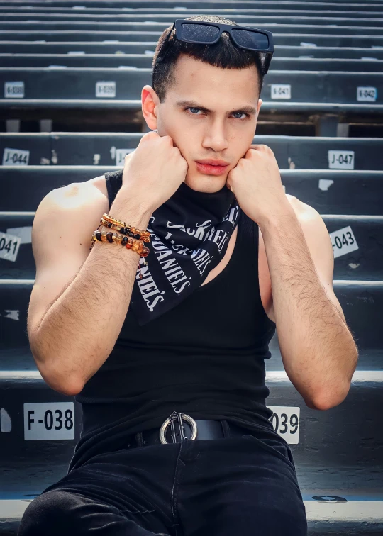 young man posing on bleachers with hands under his chin