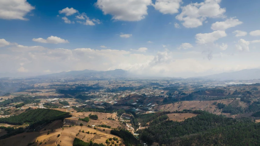 an aerial view of the countryside below a mountain