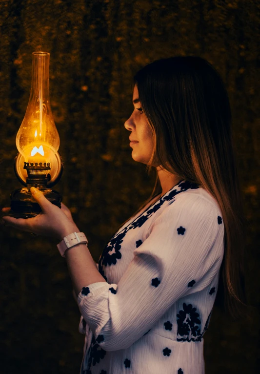 young woman with candle in hand in room