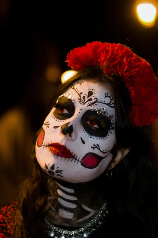 a woman with black and white face makeup is in the dark