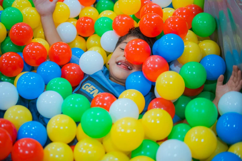 the two boys have their hands in a ball pit