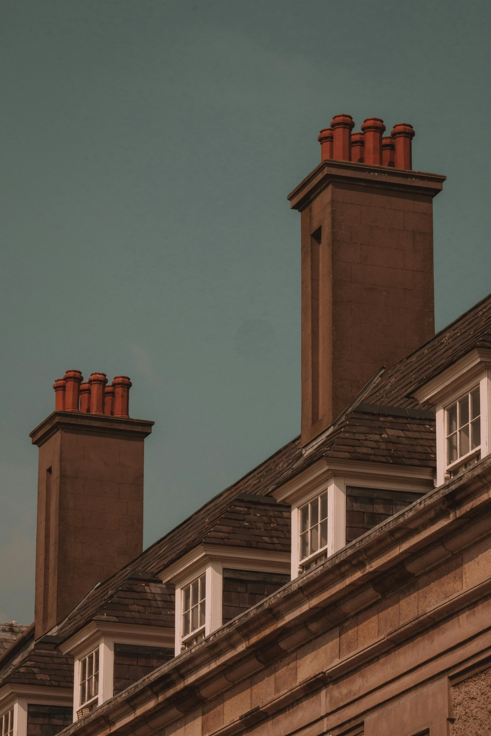 the top of two chimneys of two identical houses