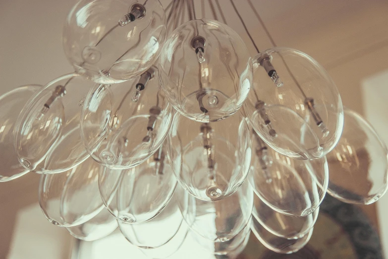 several wine glasses are hanging from a chandelier