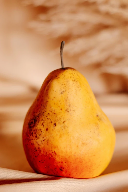 a yellow pear on a bed with a blurry background