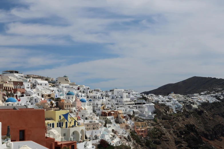 some buildings on top of a hill with hills in the background