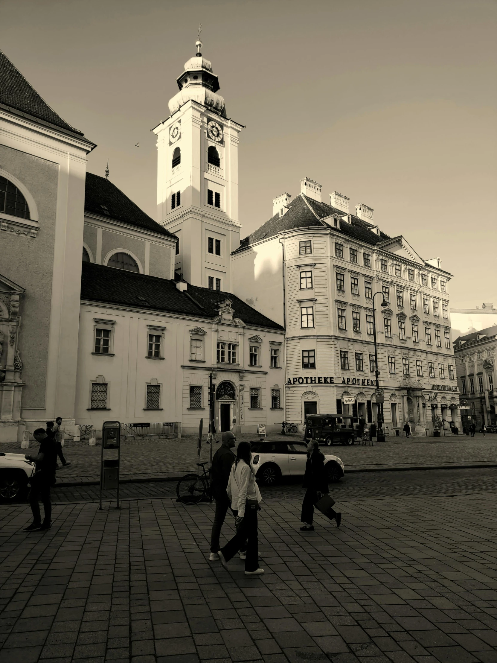 people walking through an old town square with two large buildings