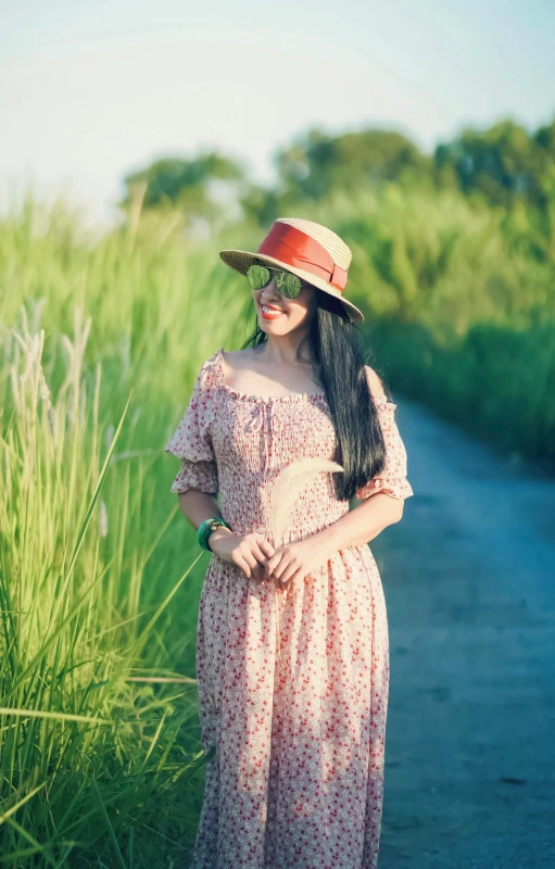 a woman in a sun hat standing next to a path