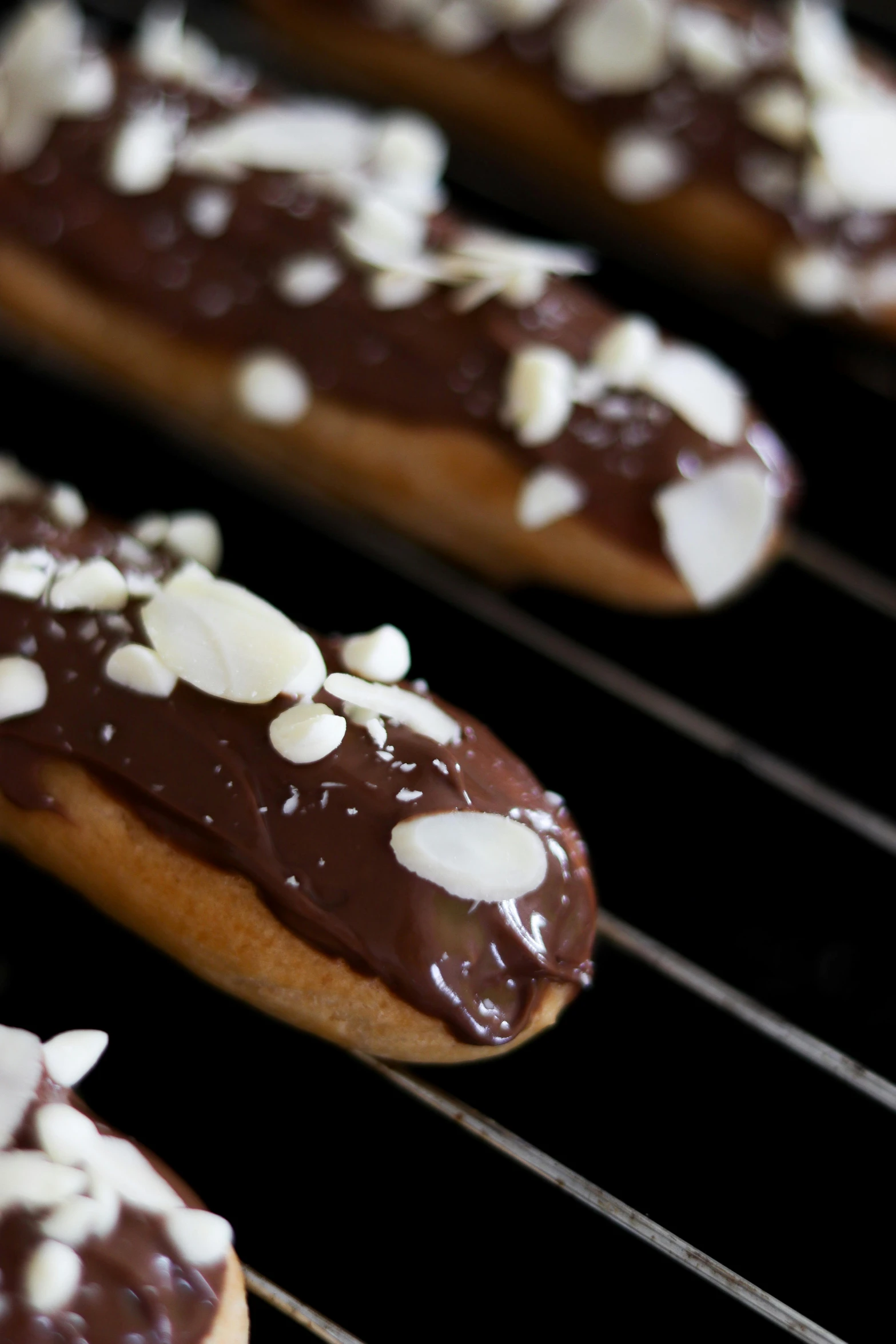 several chocolate covered cookies with white icing on a cooling rack