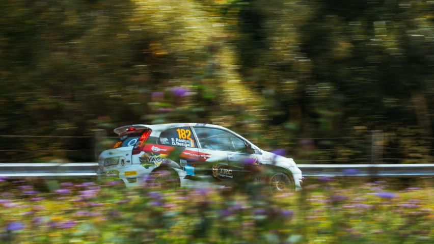 a small car is riding on the road in the countryside