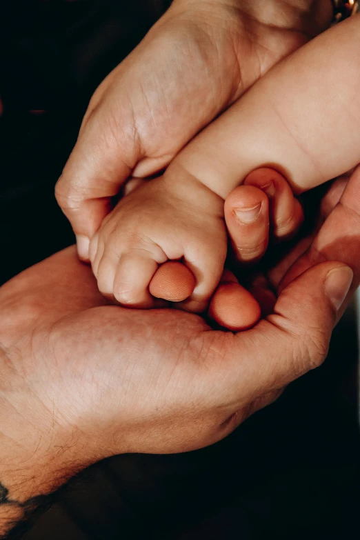 a man holding a child's hands while they hold each other