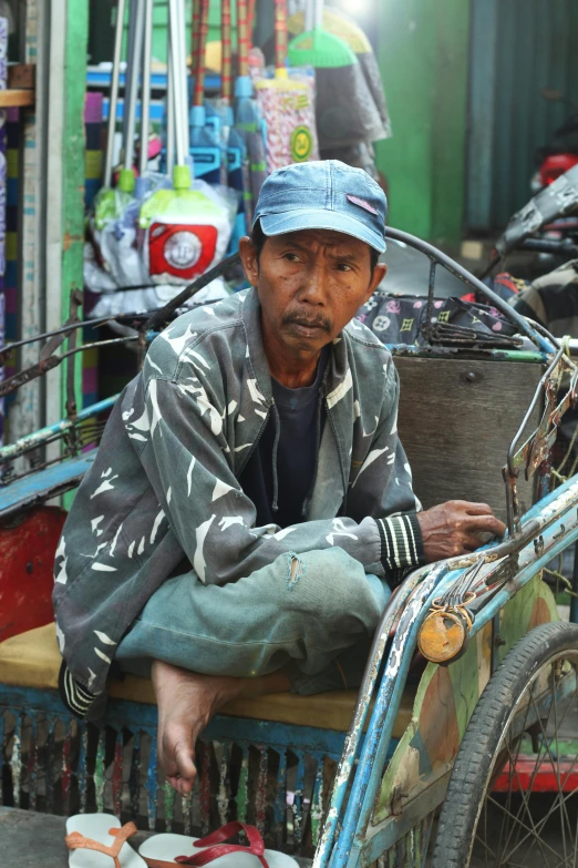 a man is sitting on a small cart in an area with other things