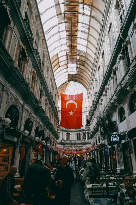 the inside of a large shopping mall with two orange flags on them