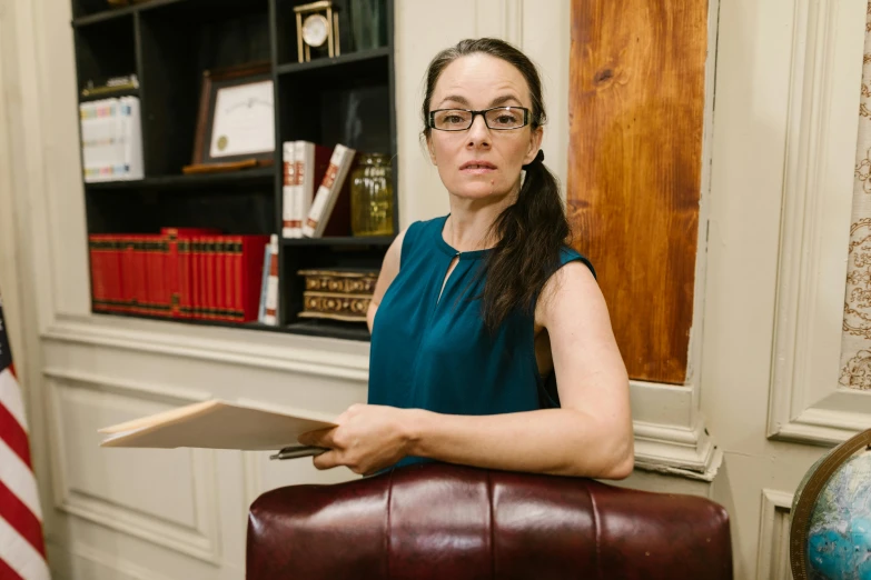 a woman is holding a file while sitting down