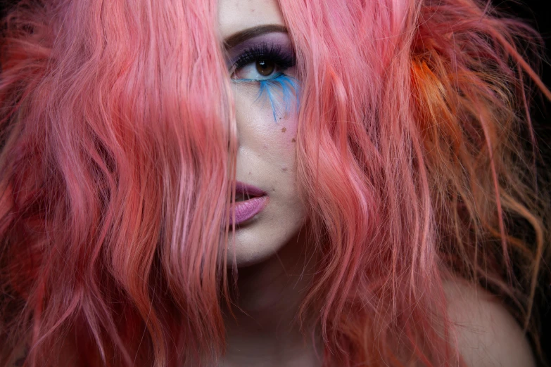 a woman with pink hair is looking at her cellphone