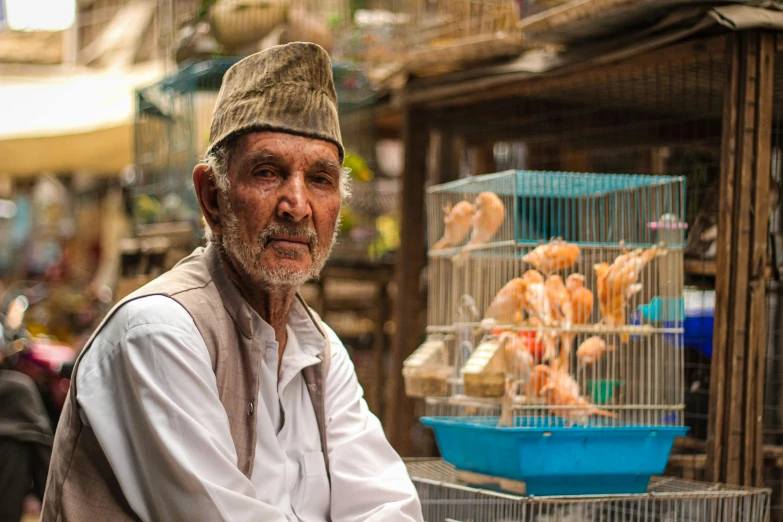 an older man in an open air market selling various meats