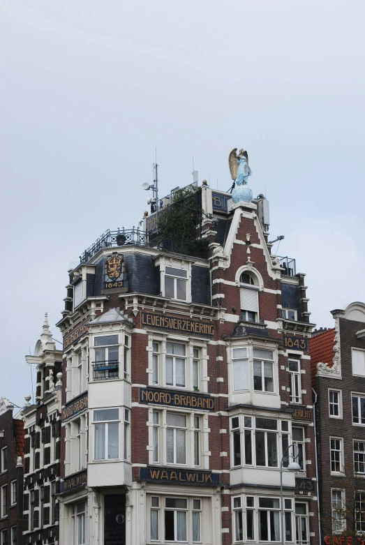 a tall building with many windows and a statue on top