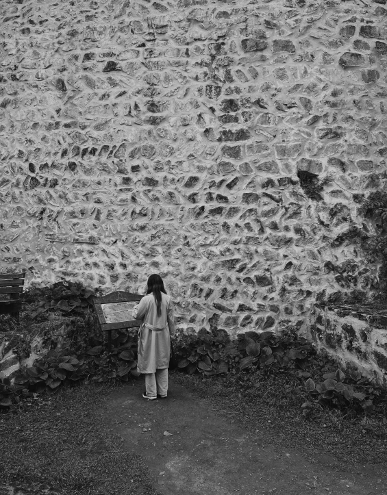 woman standing in front of stone wall