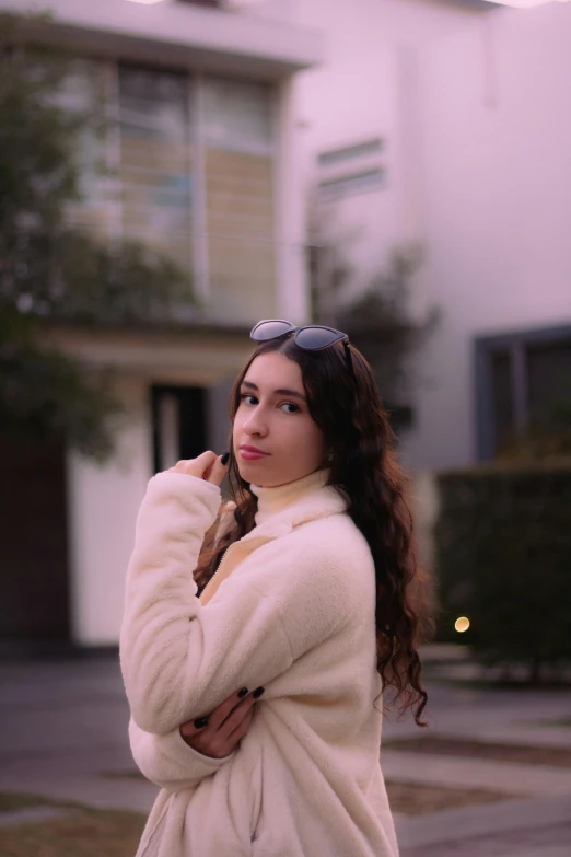 young woman posing in front of a home with a streetlight in the background