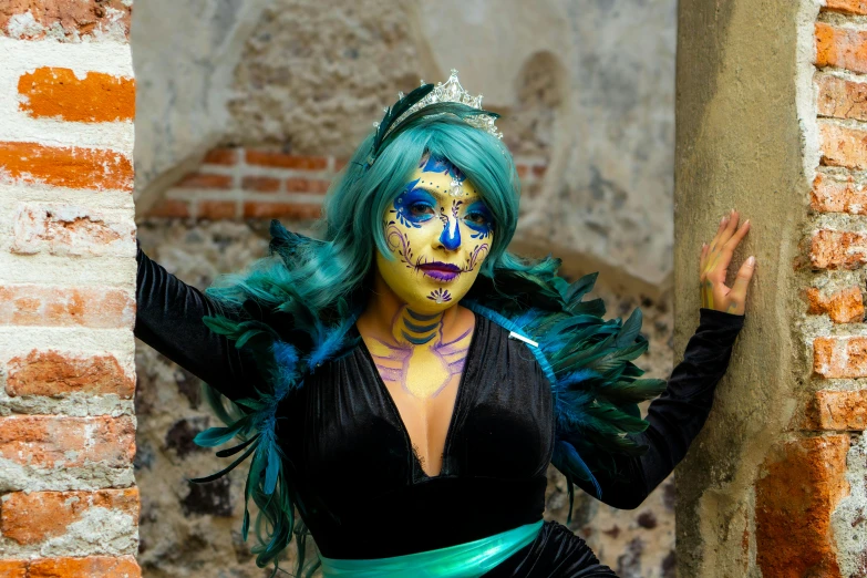 woman in colorful makeup with wings and green hair