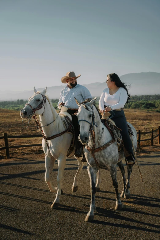 two women riding horses on an open field