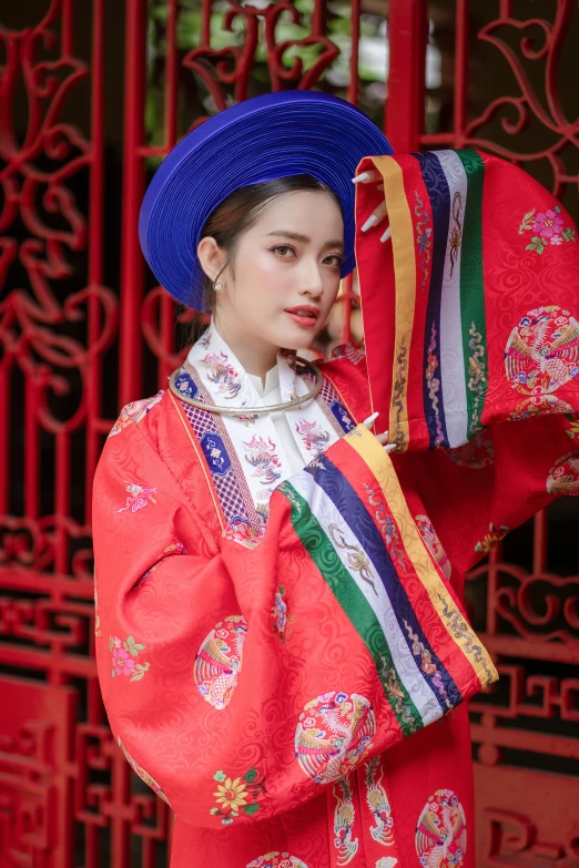 a woman in traditional dress and hat poses for the camera