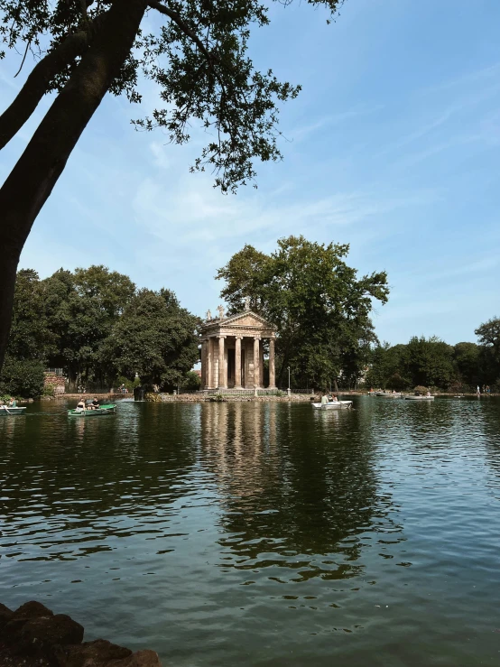 a pond and some trees and water with a building