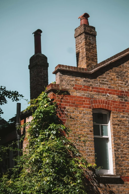 two tall brick chimneys sit next to a brown building