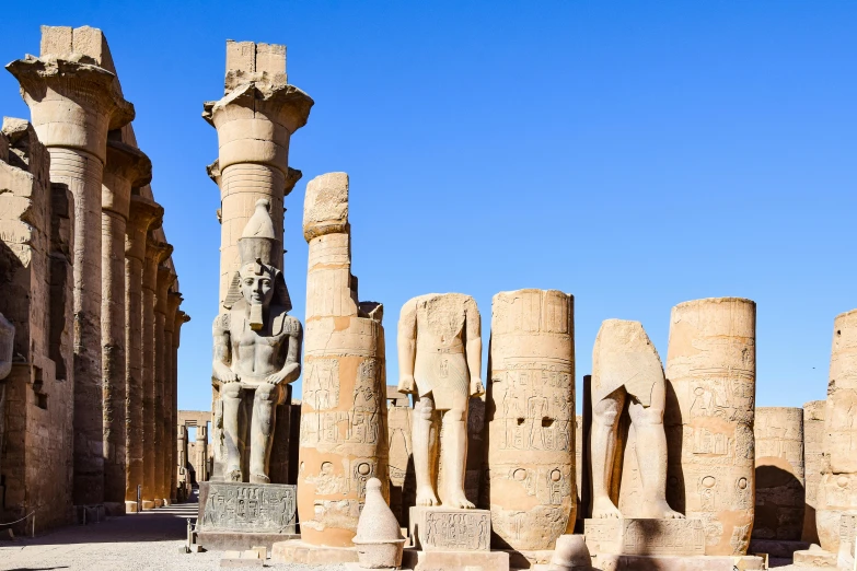 the interior of a temple, with four columns and a statue