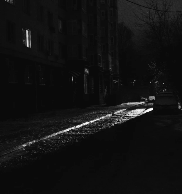 the shadows of buildings are reflected on the wet street