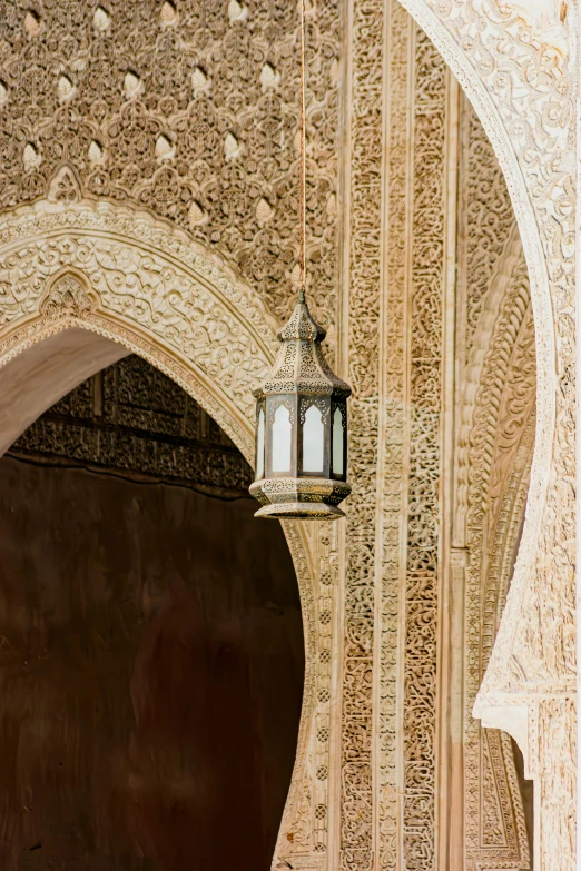 the old lamp hangs on the intricate wall