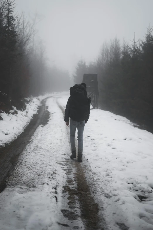 a person walking on a road covered in snow